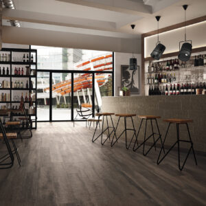 Kuni Black timber look porcelain floor tile in a modern dining room with dark wood grain texture