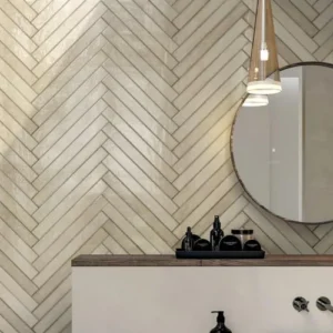 Brooklyn Oatmeal gloss wall tiles installed in a herringbone pattern on a bathroom feature wall with warm neutral tones.